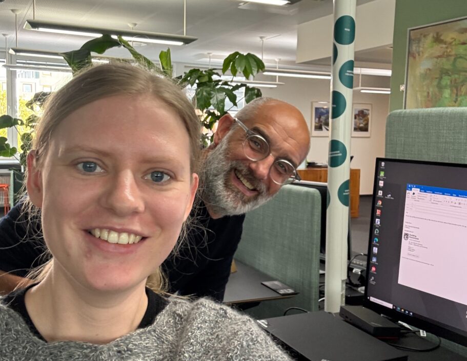 Clara og Mikael tager en selfie sammen på kontoret.
